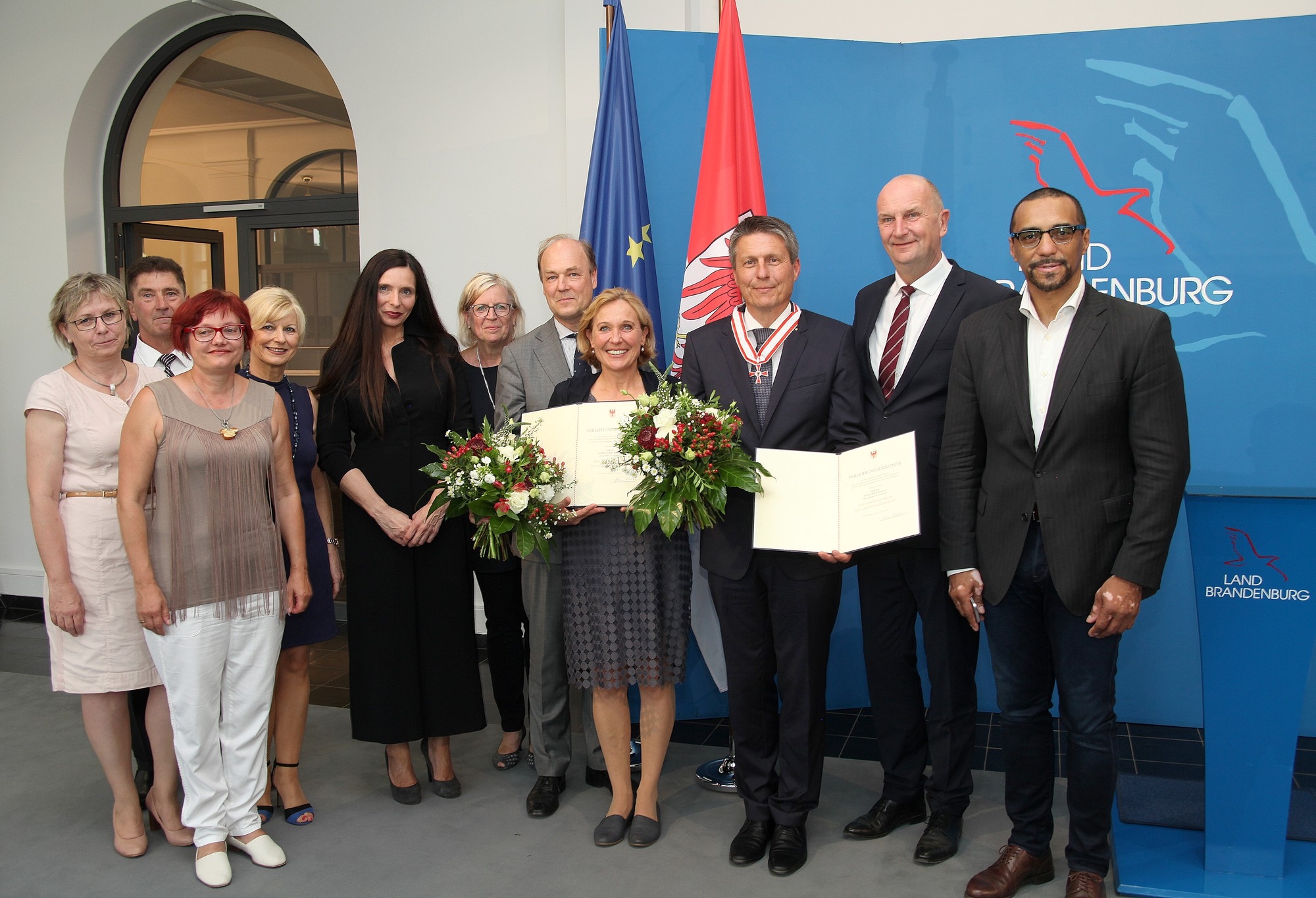 Gruppe von Menschen mit Blumenstrauß