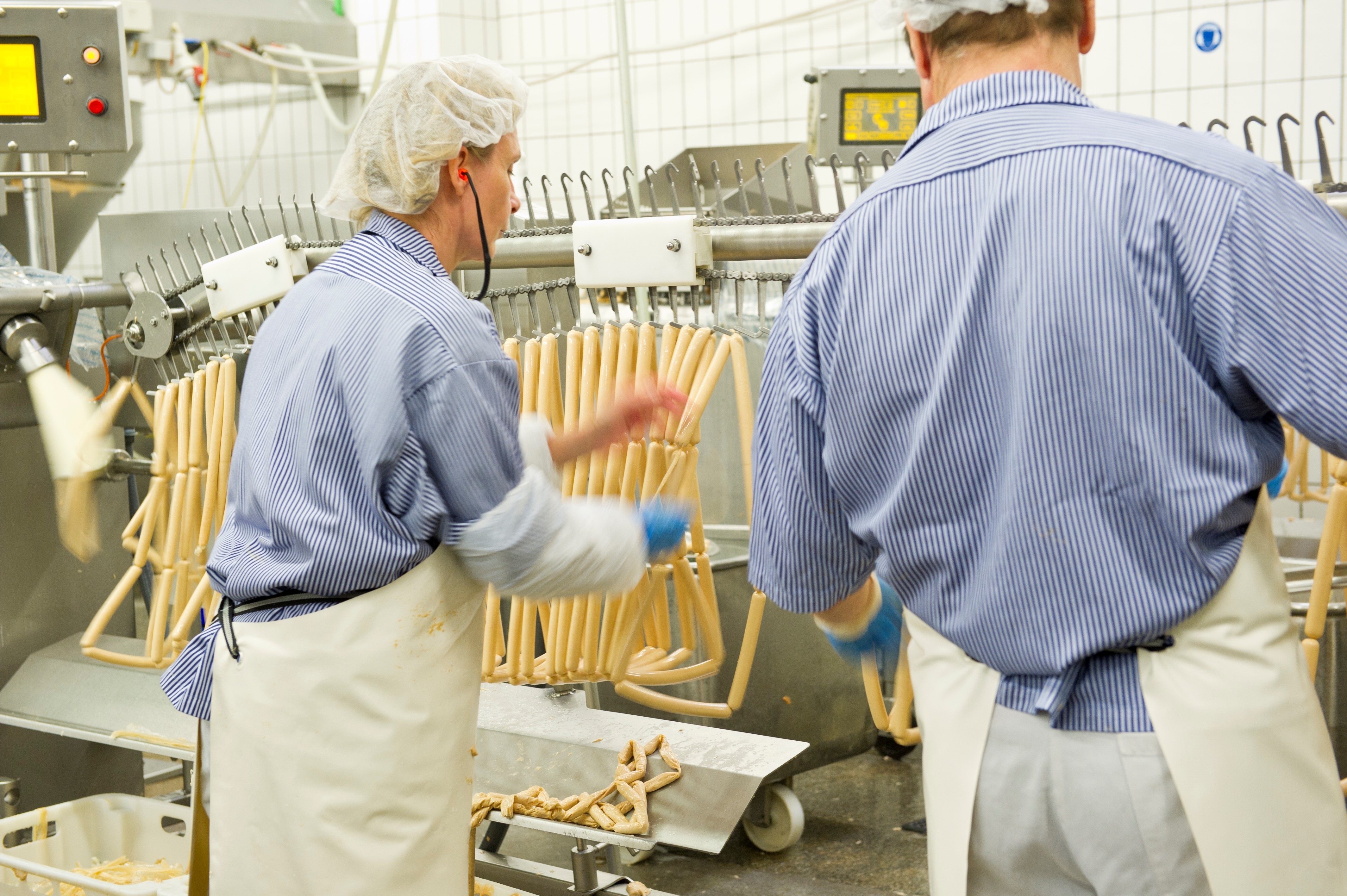 Mann und Frau verarbeiten Fleisch zu einer Wurst