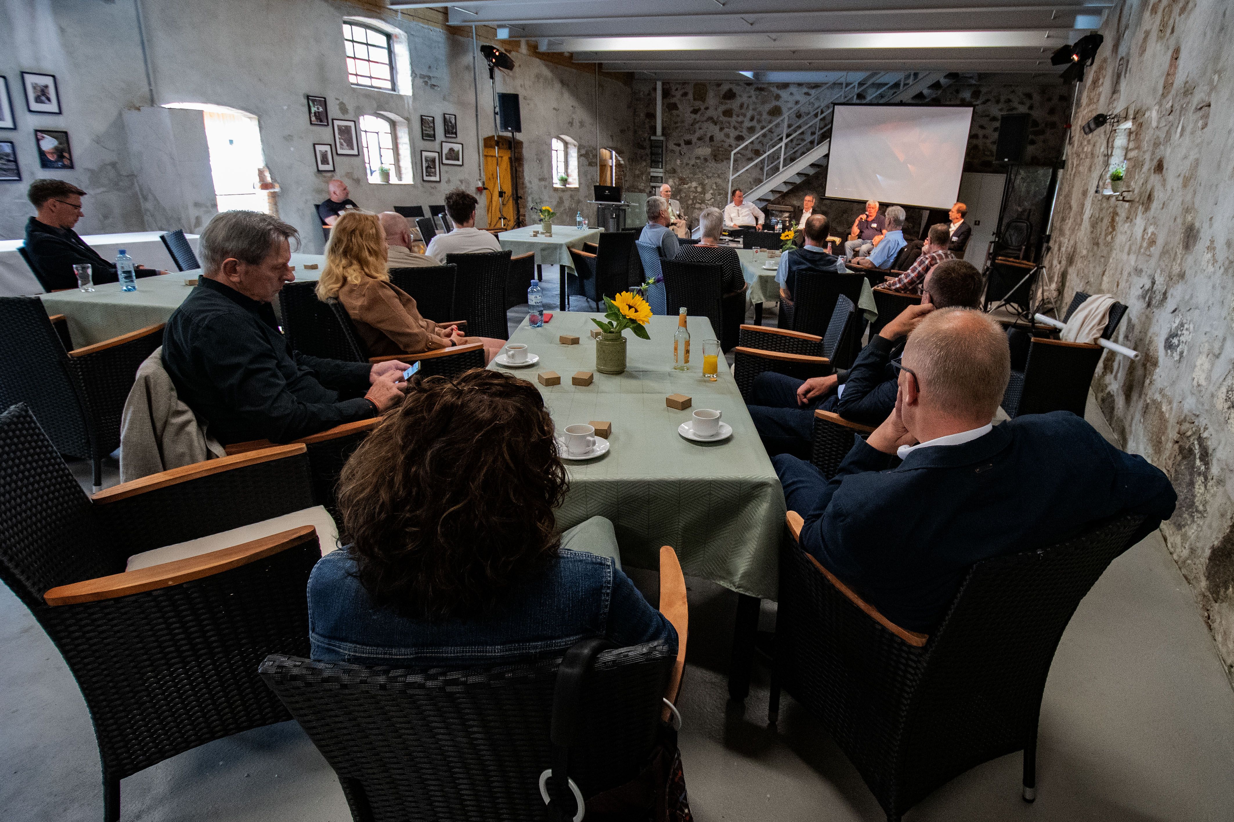 Menschen in Veranstaltungsrunde an Tischen