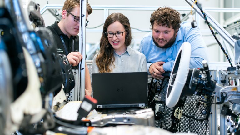 Matching Day 2022 der Universität Potsdam Junge Menschen an Laptop in Autowerk