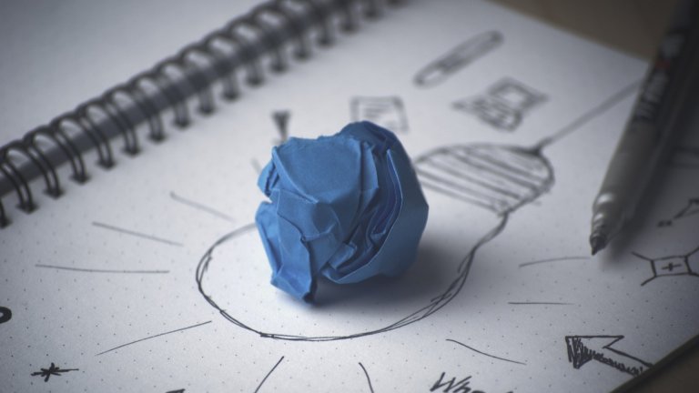 zerknülltes Papier auf Schreibblock mit Strategie zerknülltes Papier auf Schreibblock mit Strategie