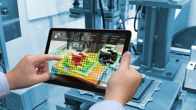 Tablet in Händen in Fabrik mit Steuerungssymbolen
