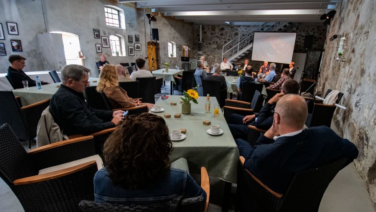 Menschen in Veranstaltungsrunde an Tischen