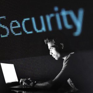 Mann vor Laptop und schwarzem Hintergrund 